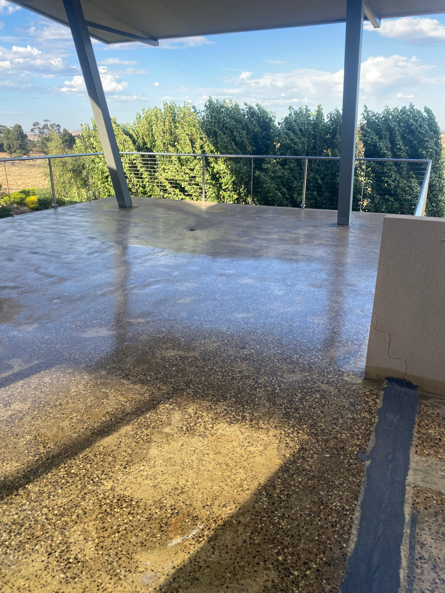 Before — weathered exposed aggregate balcony with staining and cracks